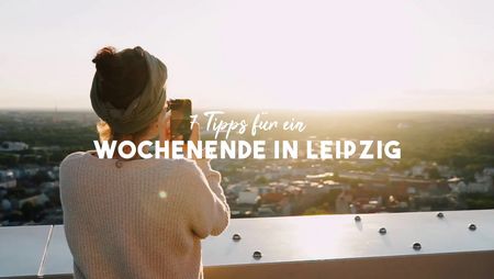 Eine Person fotografiert die Skyline von Leipzig von der Aussichtsplattform des City-Hochhauses aus.