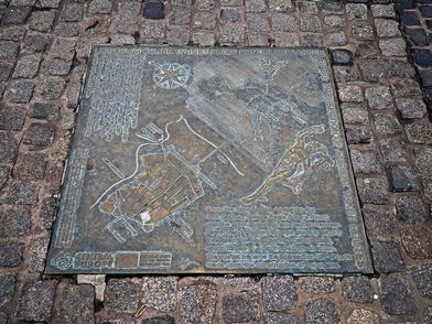 Via Regia, zu sehen ist eine in den Weg eingelassene Bodenplatte mit dem Titel "Leipzig im Schnittpunkt alter Handelsstraßen" mit geografischen Zeichnungen und Erklärungen © Andreas Schmidt