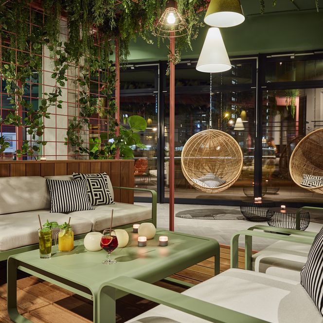 Das bild zeigt eine gemütliche Sitzecke im Hotel, der Einrichtungsstil ist urban jungle.
