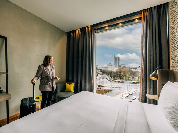 Tagungsteilnehmende beim Zimmerbezug im HYPERION Hotel Leipzig mit Blick auf die Innenstadt für Tagung & Konferenz Leipzig Convention