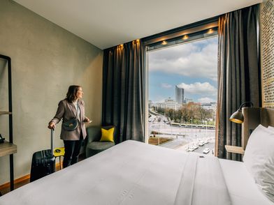 Tagungsteilnehmende beim Zimmerbezug im HYPERION Hotel Leipzig mit Blick auf die Innenstadt für Tagung & Konferenz Leipzig Convention