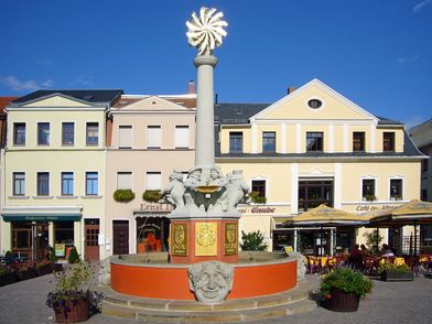 Oschatz - Altmarktbrunnen, zu sehen ist der Brunnen auf dem Oschatzer Altmarkt, dahinter der Imbiss "Hofmann's Hütte" und das Geschäft der Bäckerei Taube © Andreas Schmidt