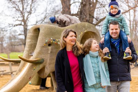 Eine Familie hat im Winter Spaß auf dem Spielplatz im Palmengarten.