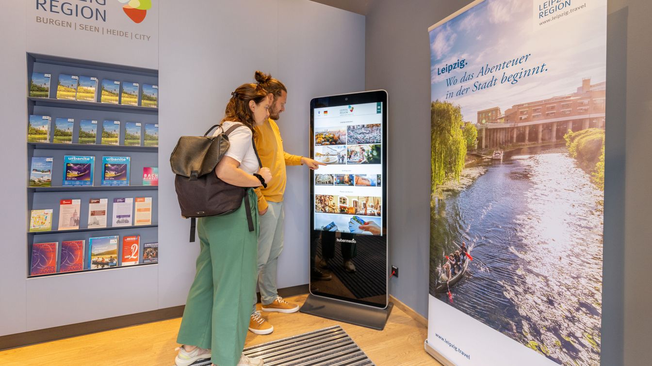 Besucher interessieren sich für die Infostele in der Tourist-Information.