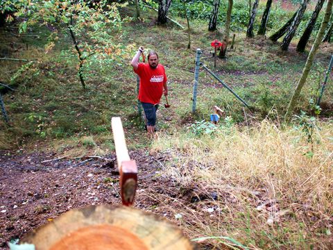 Ein Mann wirft mit einer Axt auf ein Holzziel beim 3D-Axtwerfen im Erlebnisparcours am Störmthaler See