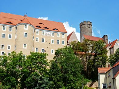 Burg Gnandstein im historischen Örtchen Gnandstein im Kohrener Land, zu sehen ist eine Außenansicht strahlend blauem Himmel und mit grünen Bäumen vor der Burg © Andreas Schmidt