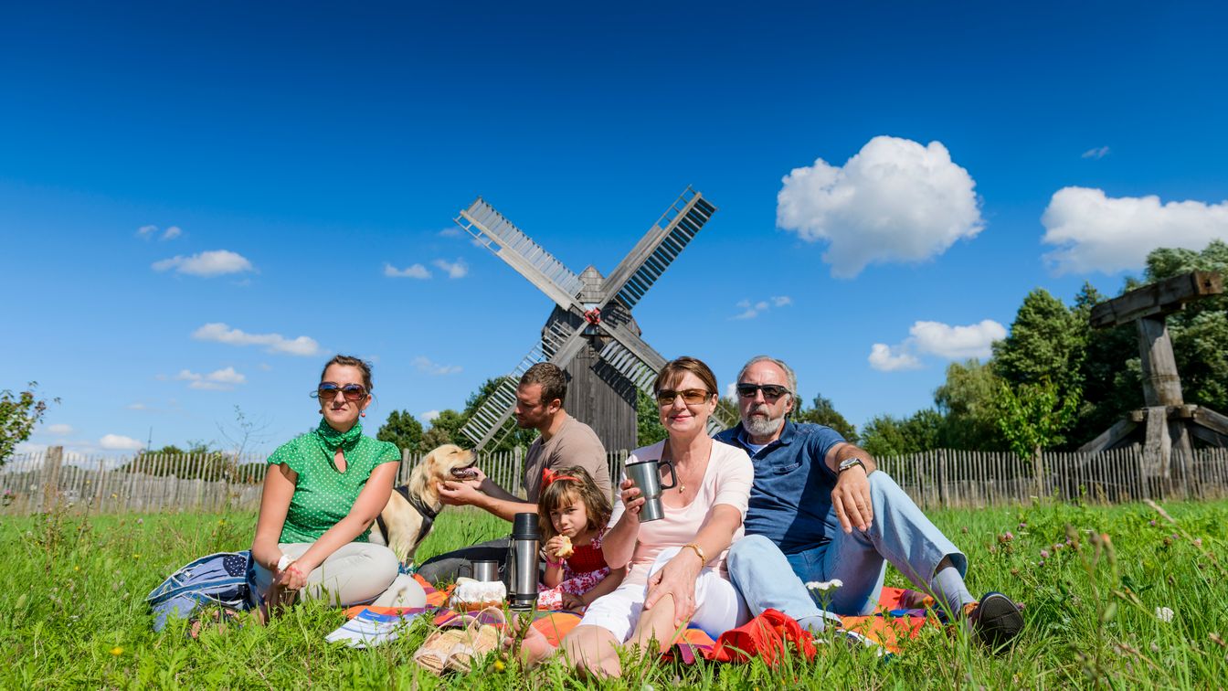 Eine Familie picknickt vor der sommerlichen Bockwindmühle in Bad Düben.