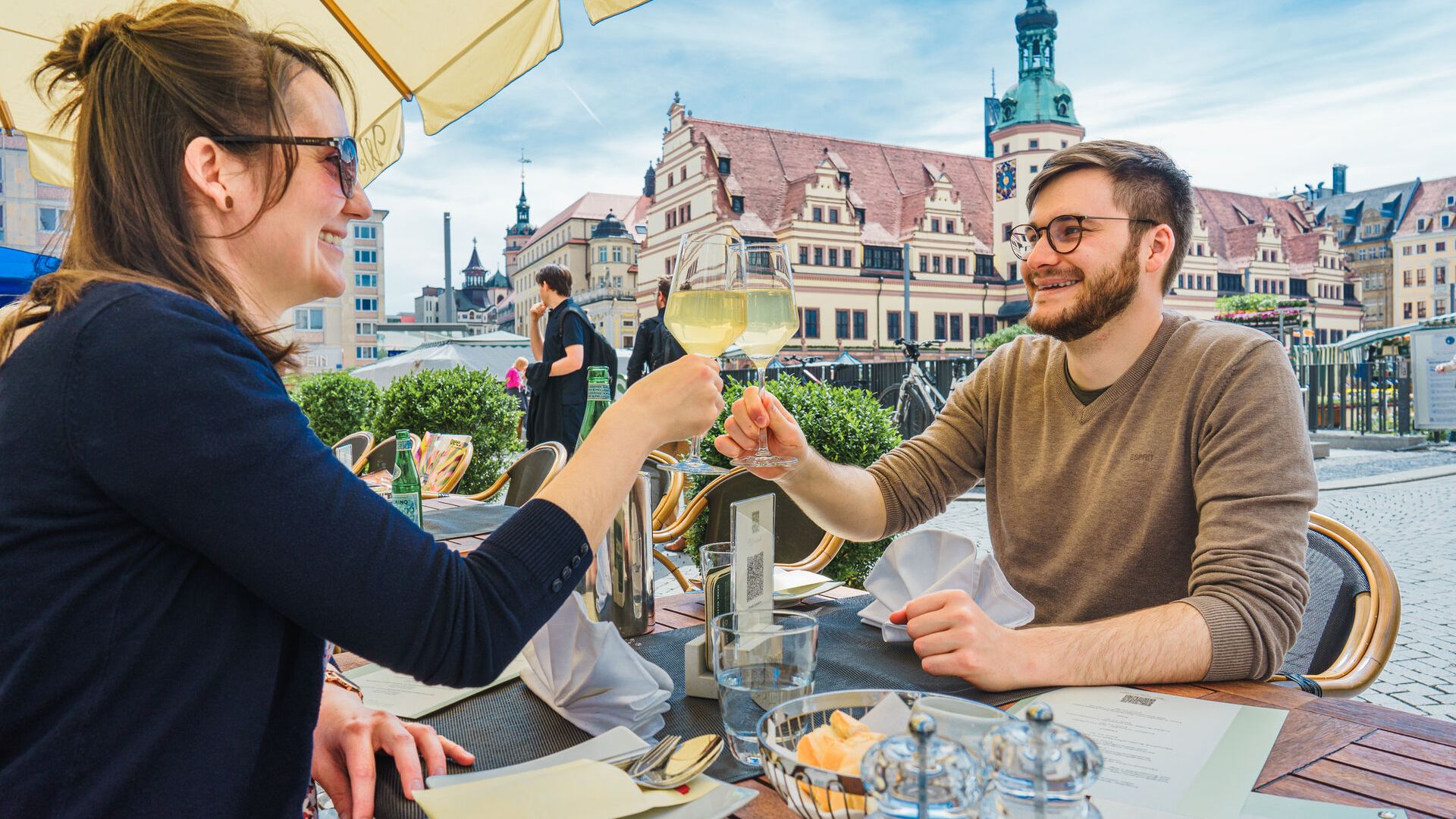 View of two guests in the outdoor seating area of the Weinstock restaurant at the edge of the market square. Restaurant, leisure time, eating out 