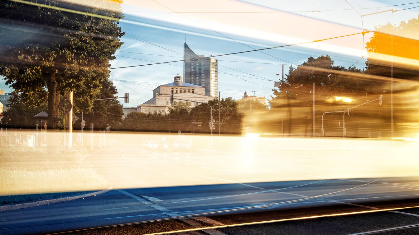 Leipziger Sehenswürdigkeiten spiegeln sich in der Scheibe der Tram.