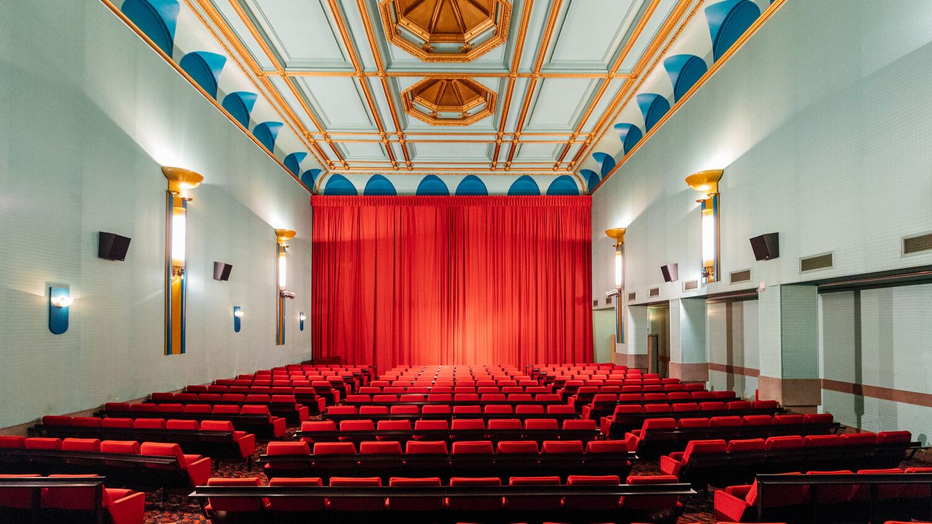 Der Kinosaal im Regina-Palast hat mit blauen und goldenen Deckenelementen und halbmondförmigen Wandlampen einen gemütlichen Retro-Charme