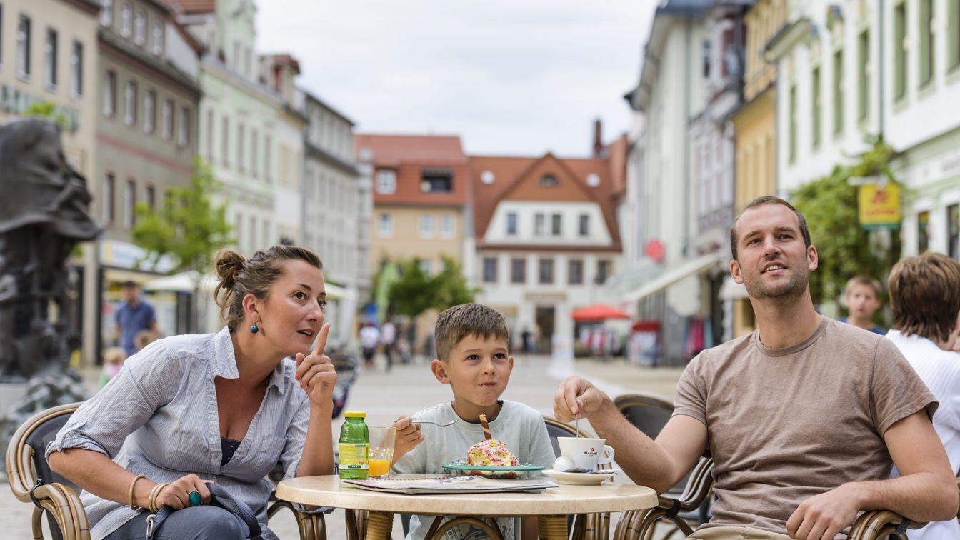 Das Bild zeigt Eltern mit ihrem Sohn in dem Außenbereich eines kleinen Cafés in der Altstadt von Döbeln.