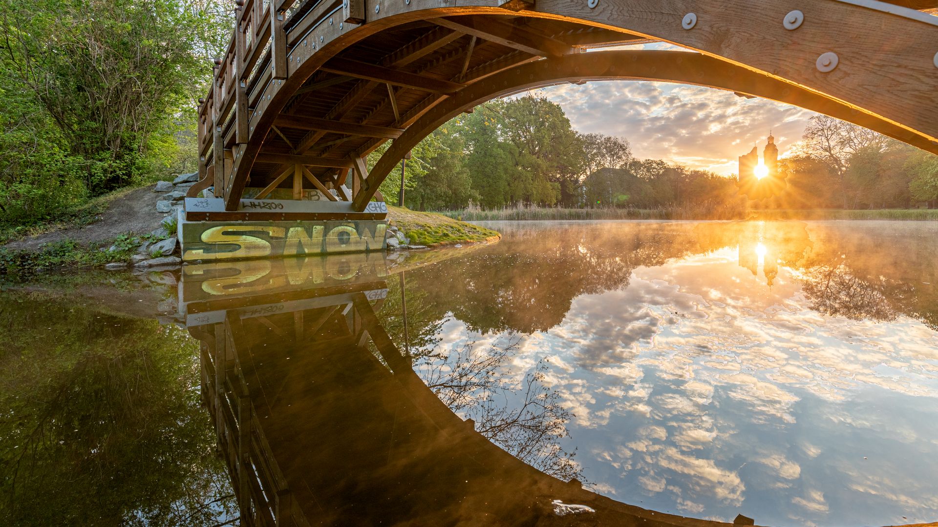 Neben einer Brücke im Johannapark lässt sich der Sonnenaufgang gut betrachten, Frühling in Leipzig, Parks 