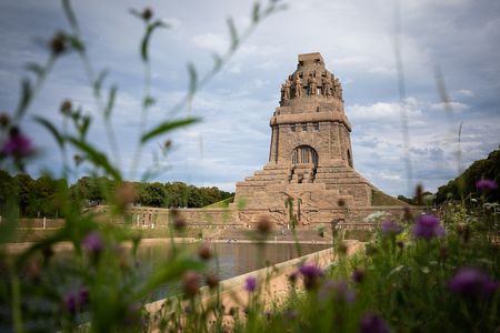 Rings um das Völkerschlachtdenkmal wachsen zahlreiche Bäume und das Areal ist parkähnlich grün.