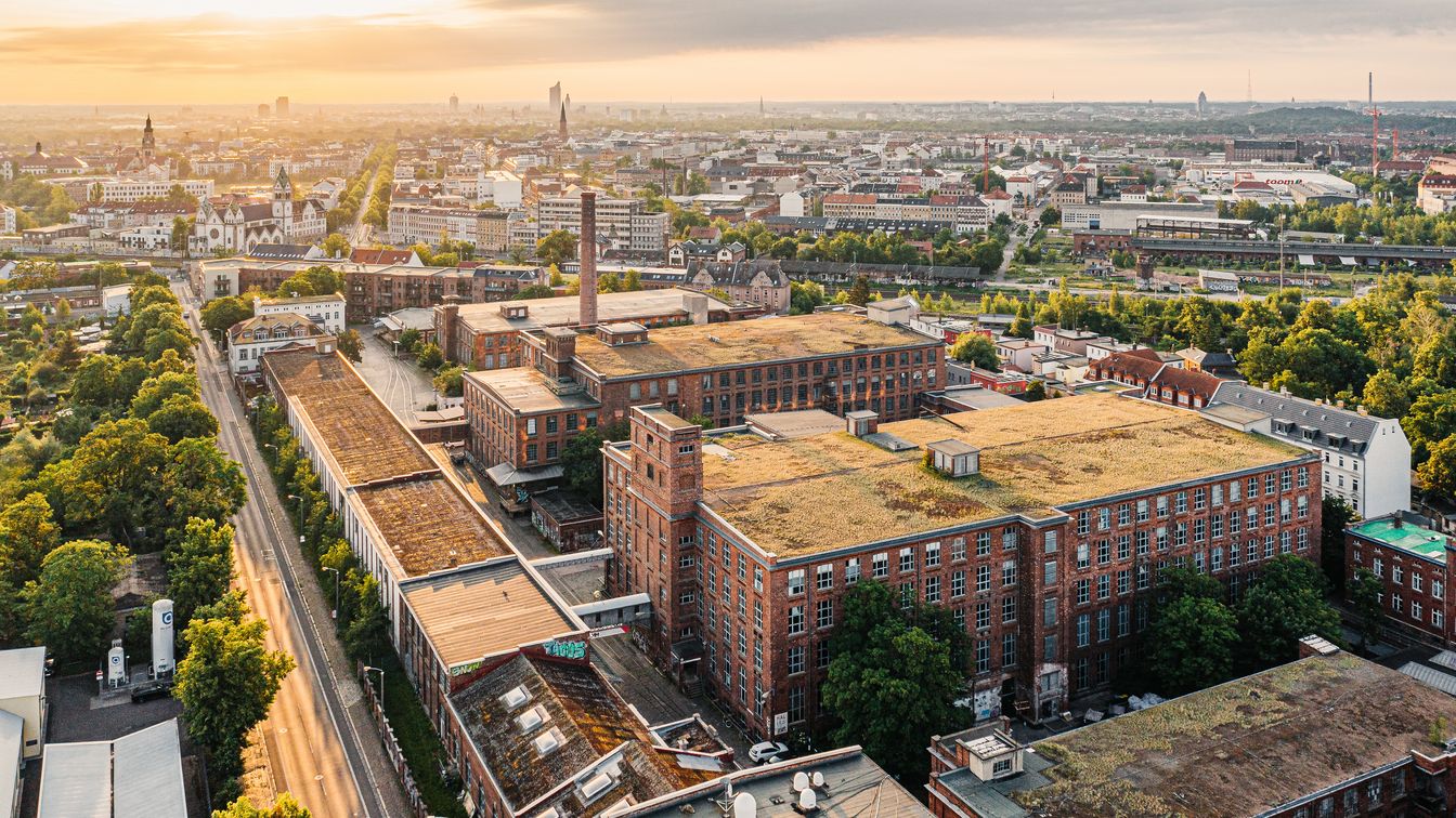 Drohnenaufnahme der ehemaligen Leipziger Baumwollspinnerei in Leipzig Plagwitz bei Sonnenaufgang, in dem sich heute das Kunstzentrum Spinnerei befindet
