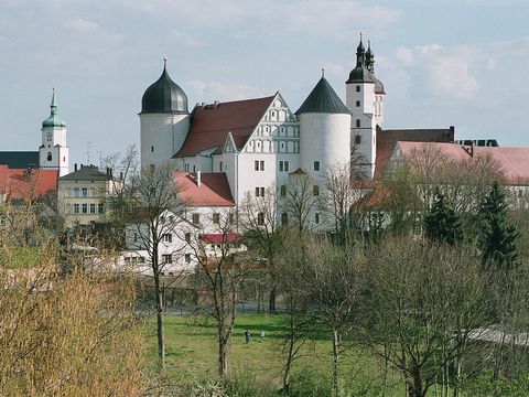 Das Schloss Wurzen erhebt sich mit seiner weißen Fassade von der Stadt.
