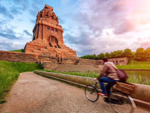 Fahrradfahrer vor dem Völkerschlachtdenkmal in Leipzig mit Abendhimmel, Sehenswürdigkeiten in Leipzig, Freizeit, Radfahren