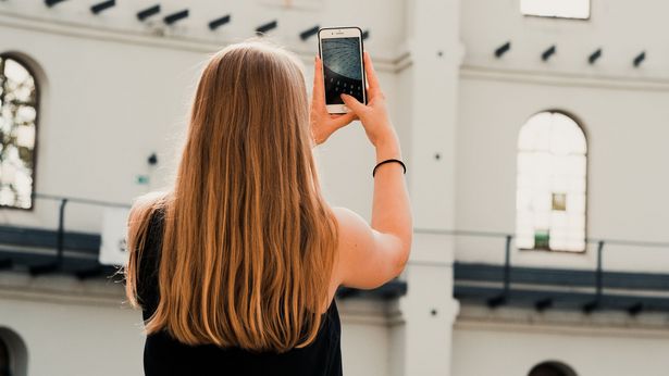 Eine Frau fotografiert mit ihrem Handy das Dach des Panometers, Museen, Architektur in Leipzig