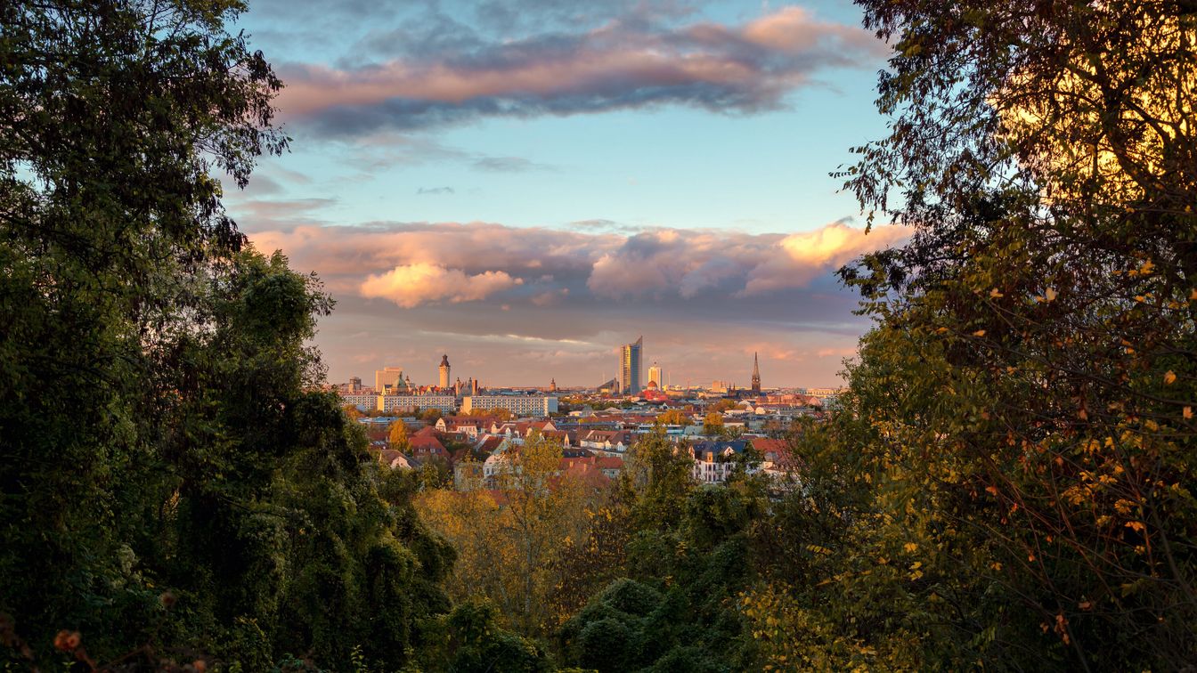 Vom Fockeberg in Leipzig blickt man zwischen Grün auf die Skyline der Stadt
