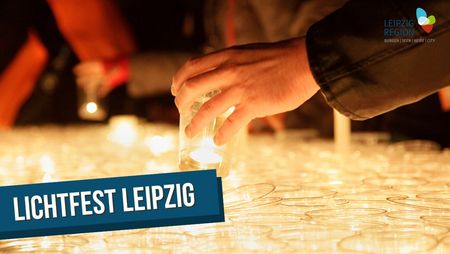 Ein Mensch stellt einen durchsichtigen Becher, in dem sich ein Teelicht befindet, zu einer großen Ansammlung weiterer Becher, die alle warmes Licht verströmen