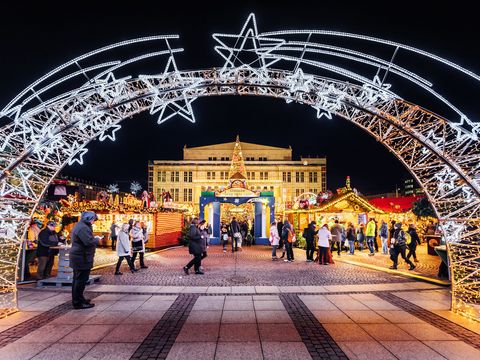 Entrée du marché de Noël et de la Forêt des contes sur la place Augustusplatz le soir, avec l’Opéra en arrière-plan