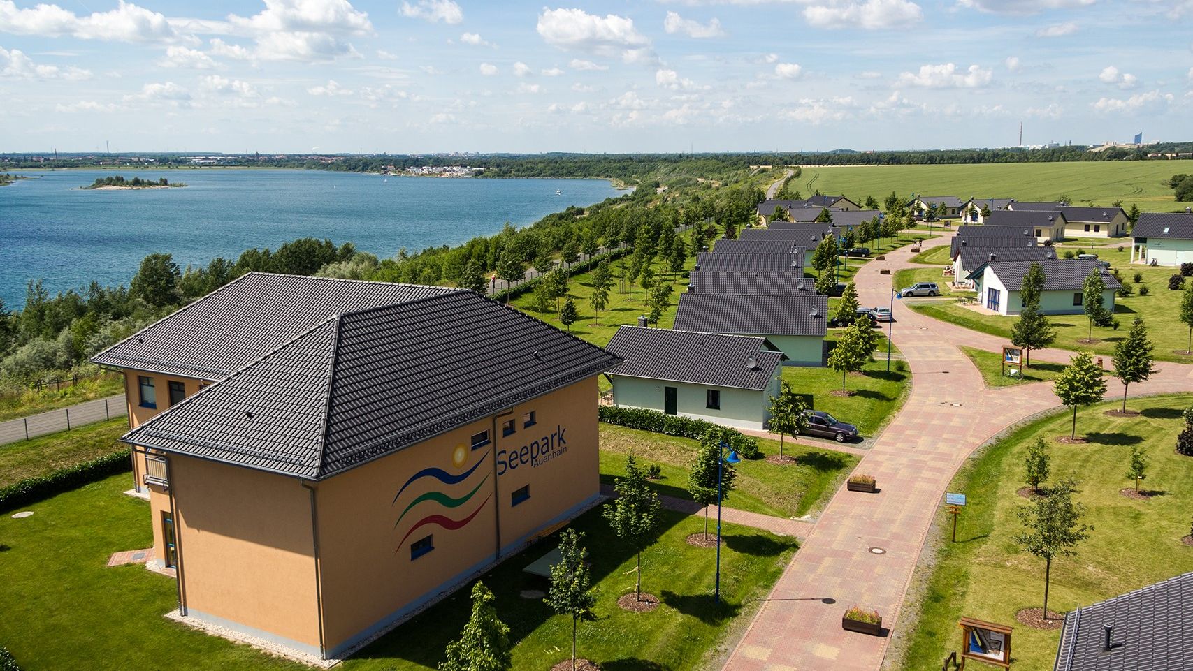 Luftaufnahme Seepark Auenhain mit Ferienhäusern und Blick auf den See