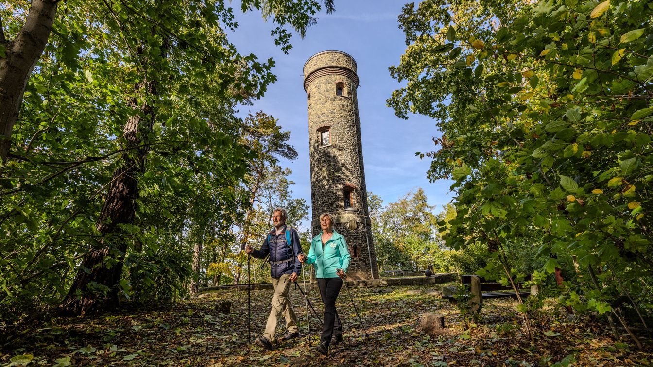 Das Bild zeigt ein Ehepaar beim Wandern in der herbstlichen Landschaft rund um den Wachbergturm bei Waldheim.