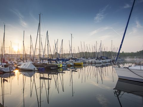 Boats and yachts at the Lake Cospuden marina at sunset.