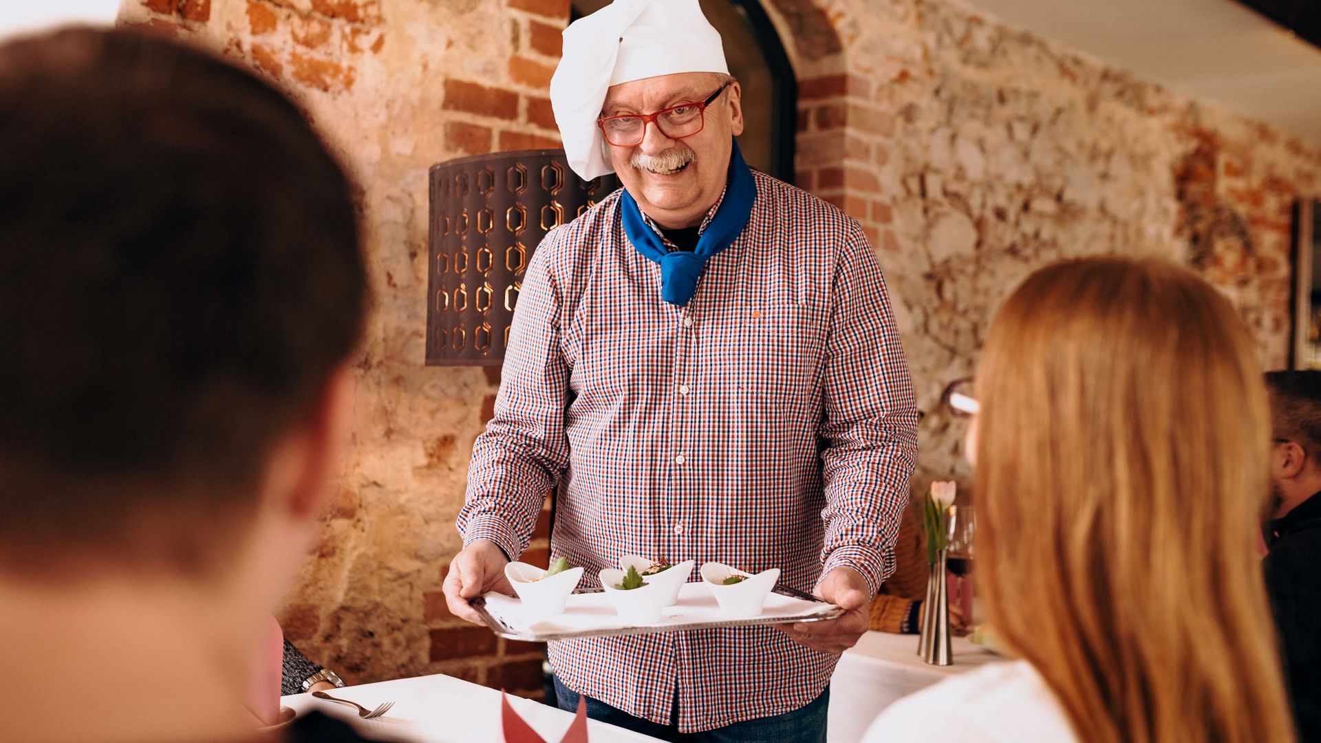 V radničním sklípku v Grimmě ukazuje průvodce a kuchař Frank Ziegra jednomu páru předkrmy z kuchyně během kulinářské prohlídky města Grimma, restaurace a kavárny