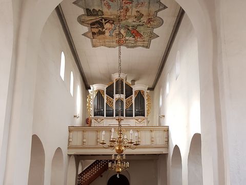 Blick in die Kirche auf den gold verzierten Orgelprospekt und die Deckenbemalung mit der Geburt Jesu