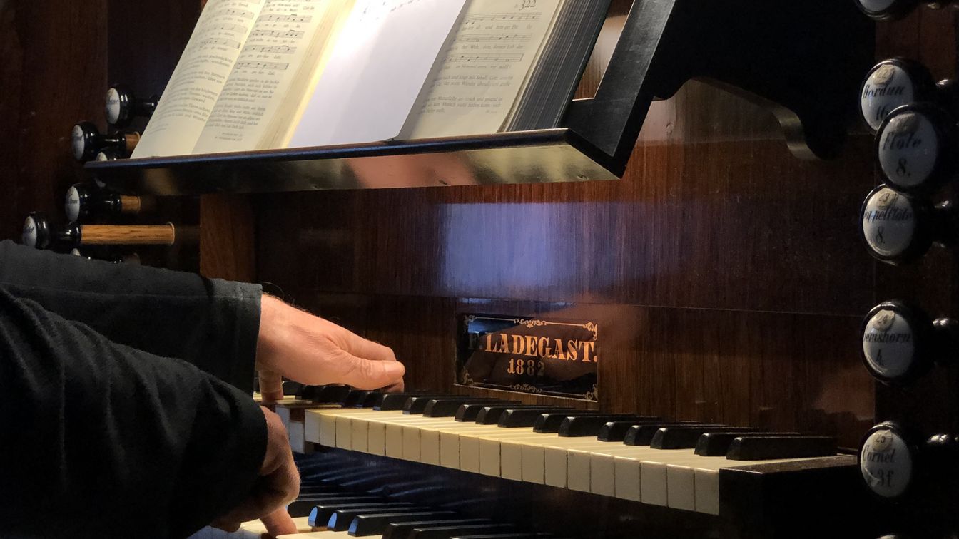 Ein Organist spielt auf dem Manual einer Orgel.