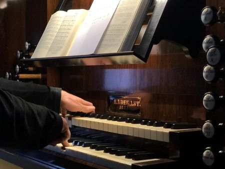 Ein Organist spielt auf dem Manual einer Orgel.