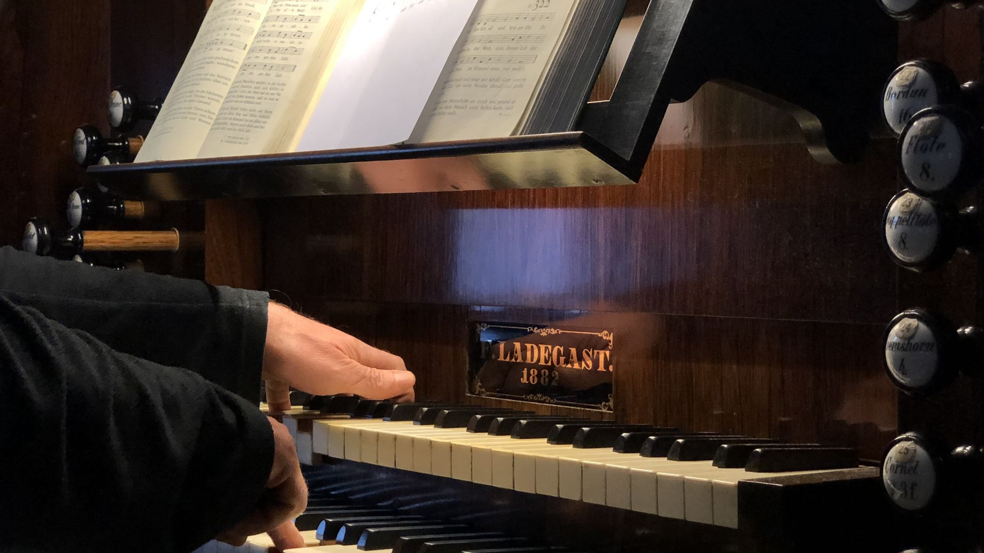 Ein Organist spielt auf dem Manual einer Orgel.