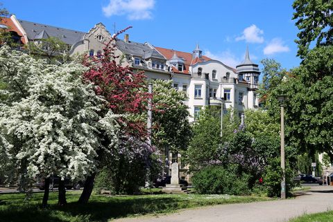 Hinter den blühenden Bäumen am Nordplatz befinden sich denkmalgeschützte Häuser, Frühling, Architektur in Leipzig