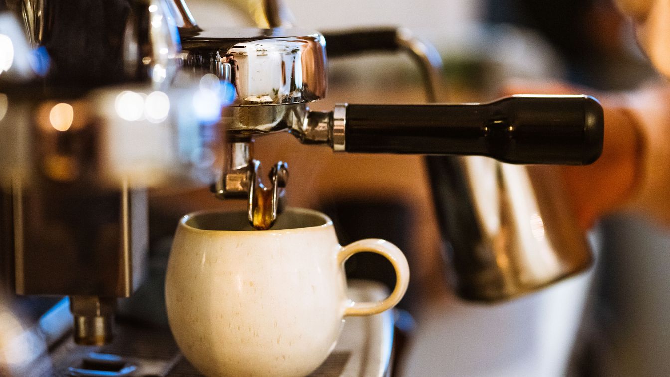 Eine Kaffeetasse steht bereit für frischen Kaffee aus der Siebträgermaschine.
