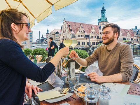 Ein Blick auf zwei Gäste im Außenbereich des Restaurants Weinstock am Rand des Marktplatz.