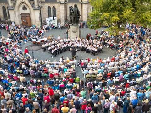 Eine große Menschenmenge steht am Bachdenkmal auf dem Thomaskirchhof an dem ein Orchester spielt