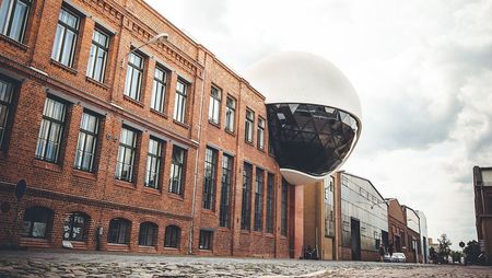 Die Oscar Niemeyer Sphere in Leipzig zeichnet sich durch eine gigantische weiße Kugel aus, die aus einem roten Backsteinbau ragt