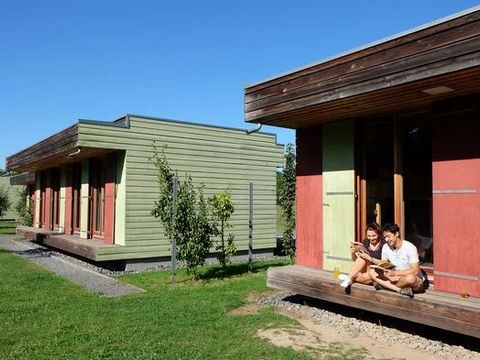 Zwei Jugendliche sitzen entspannt auf der Veranda eines Bungalows im Europäischen Jugendcamp in Oschatz.