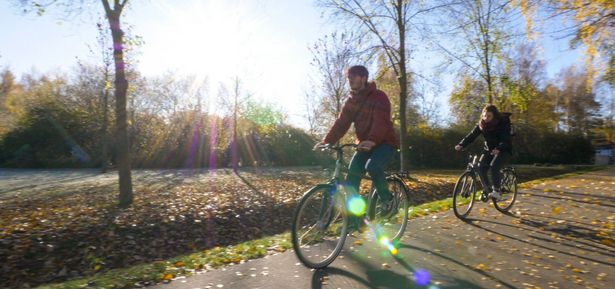Zwei Fahrradfahrer*innen fahren im Herbst auf einem Fahrradweg entlang, Fahrradfahren in der Region, Aktiv