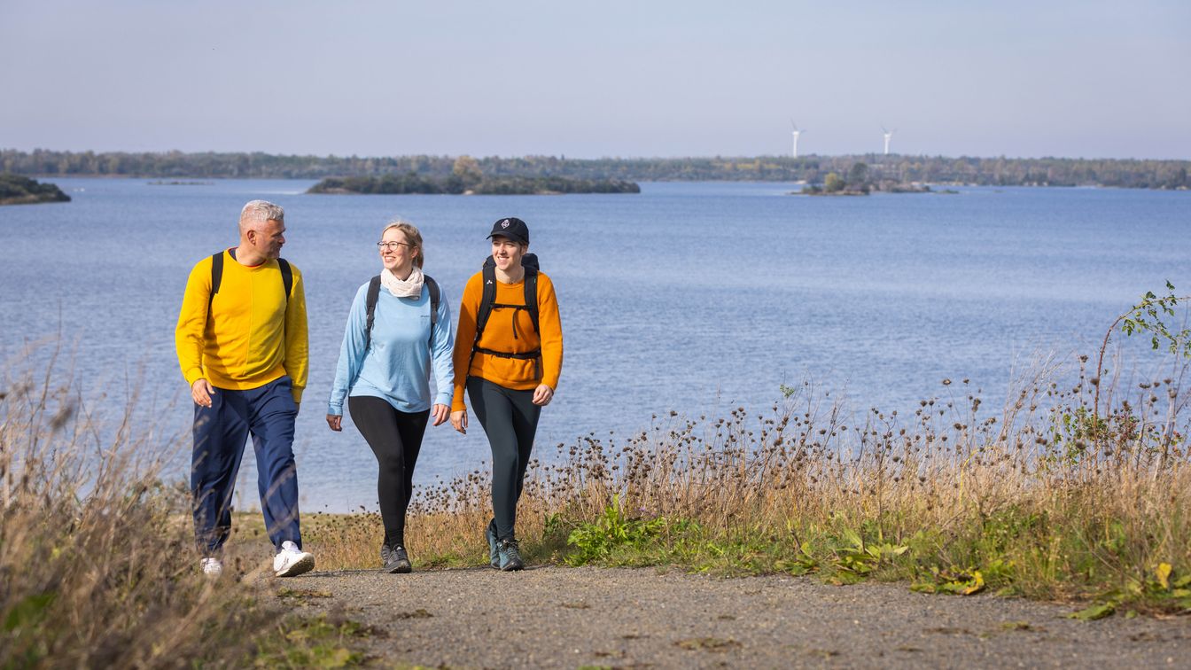 Das Bild zeigt eine Gruppe Wanderer an dem See-Rundweg am Schladitzer See.