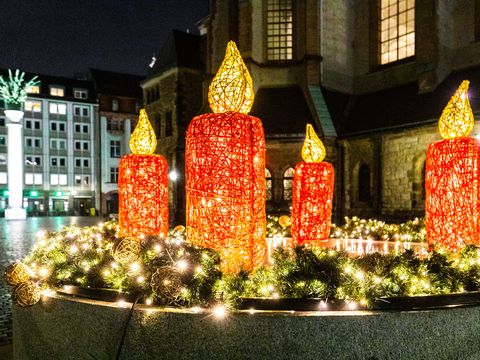 Ein überdimensionale Lichtinstallation als Adventskranz mit roten Kerzen erhellt den Nikolaikirchhof in Leipzig