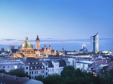 Blick auf die abendliche Skyline von Leipzig mit dem City-Hochhaus und Neuem Rathaus.
