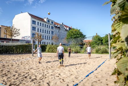 Eine Gruppe hat Spaß beim Beachvolleyball in Reudnitz 