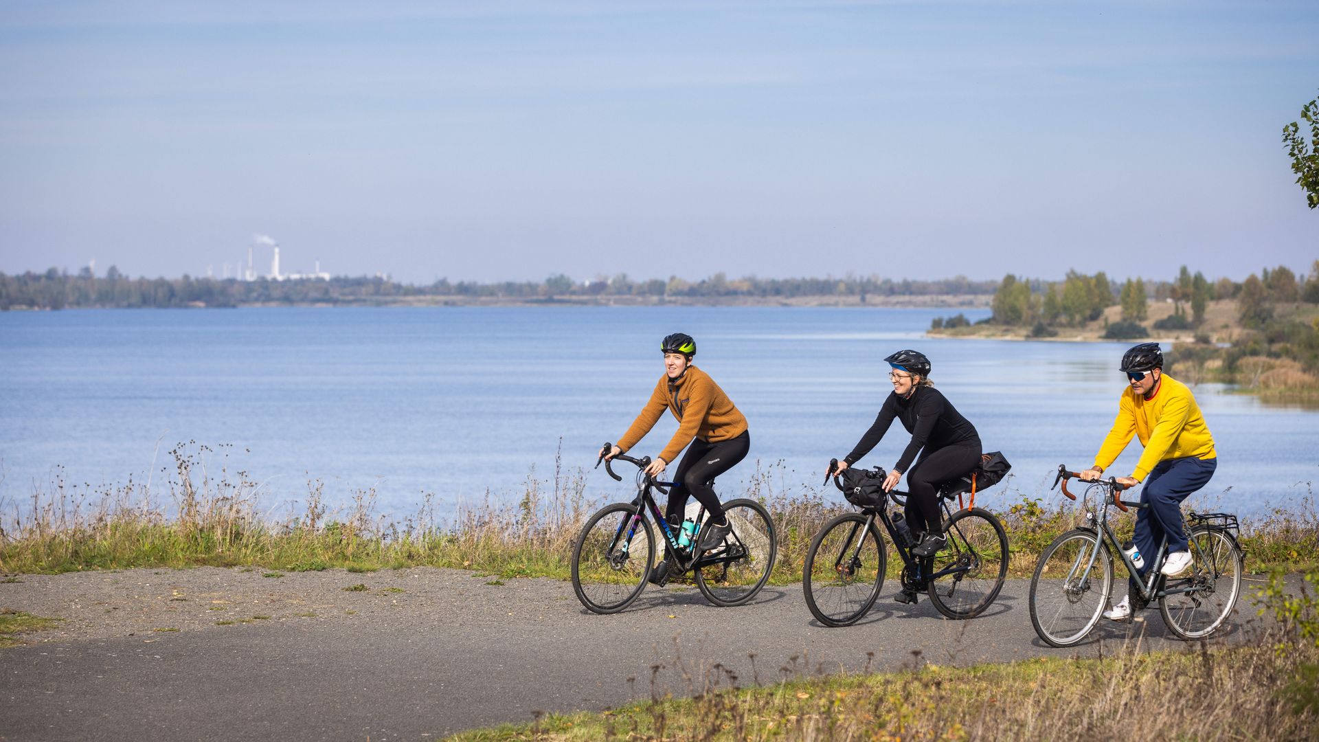Das Bild zeigt drei Radfahrer auf dem See-Rundweg. 