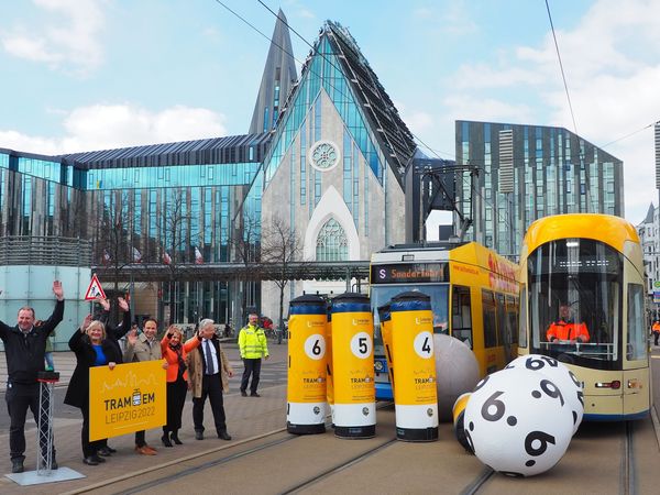 Tram-EM 2022 in Leipzig: Straßenbahn-Bowling auf dem Augustusplatz, zu sehen sind zwei Trams der LVB, wie sie gegen zwei riesige Bälle fahren und damit versuchen riesige Kegel umzufahren, daneben stehen Zuschauer - Foto: Helge-Heinz Heinker