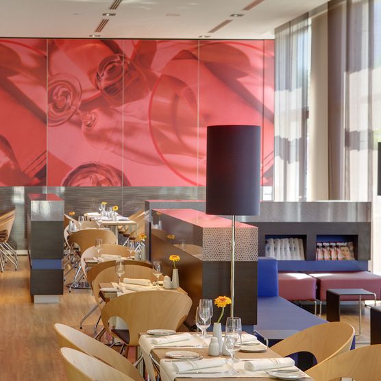 Bild zeigt geschmackvoll eingerichtetes Restaurant mit rotem Wandgemählde