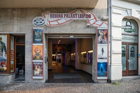 Je ziet de ingang van het Regina Palace, omringd door filmposters.