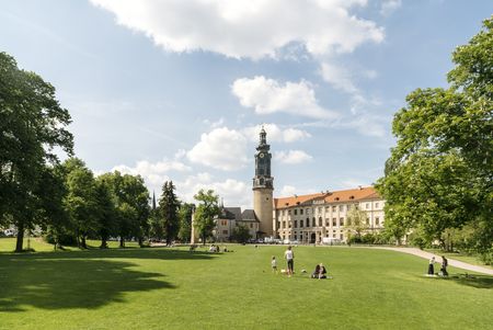 Der Blick auf das Stadtschloss Weimar von der Bastille in Weimar aus. Davor ist eine Weise mit Menschen.