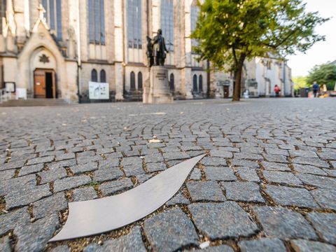Im Vordergund ist eine Note der Notenspur. Im Hintergrund ist die Thomaskirche