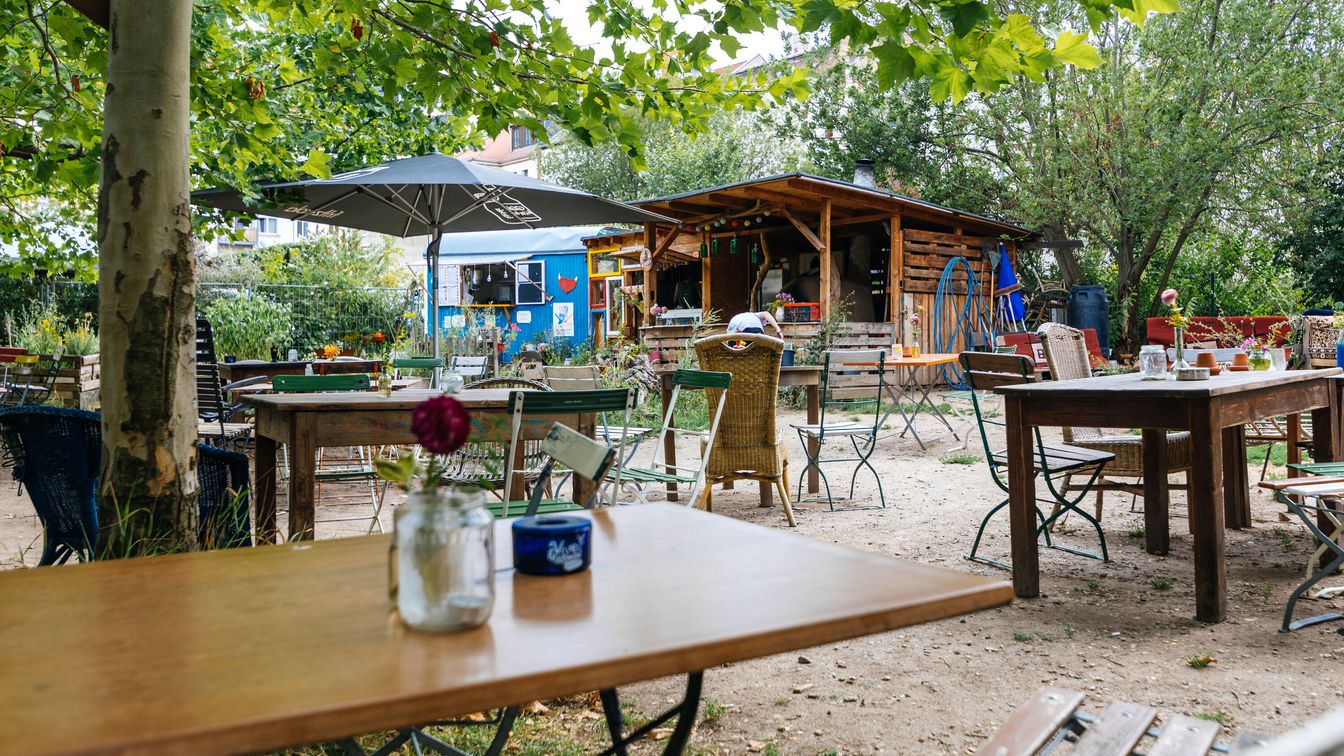 Im Cafégarten sitzt man gemütlich auf bunt zusammengewürfelten Sitzgelegenheiten.